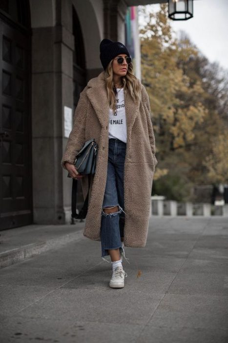 torn jeans and beige jacket