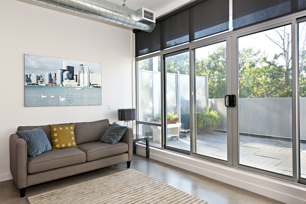 a common room with a sofa and its large glass door