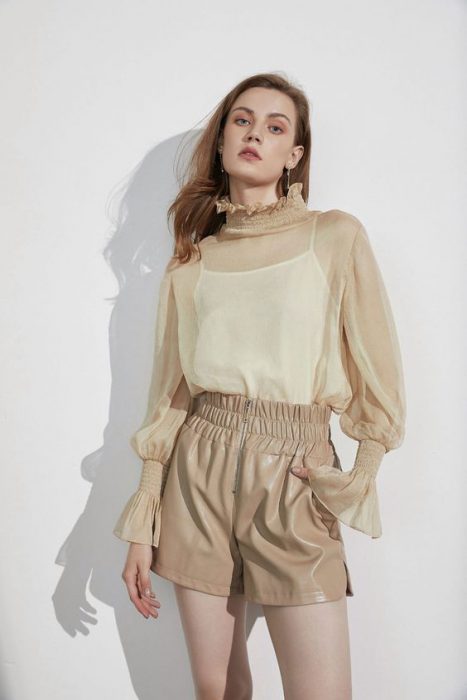 beige rubberized shorts and beige blouse